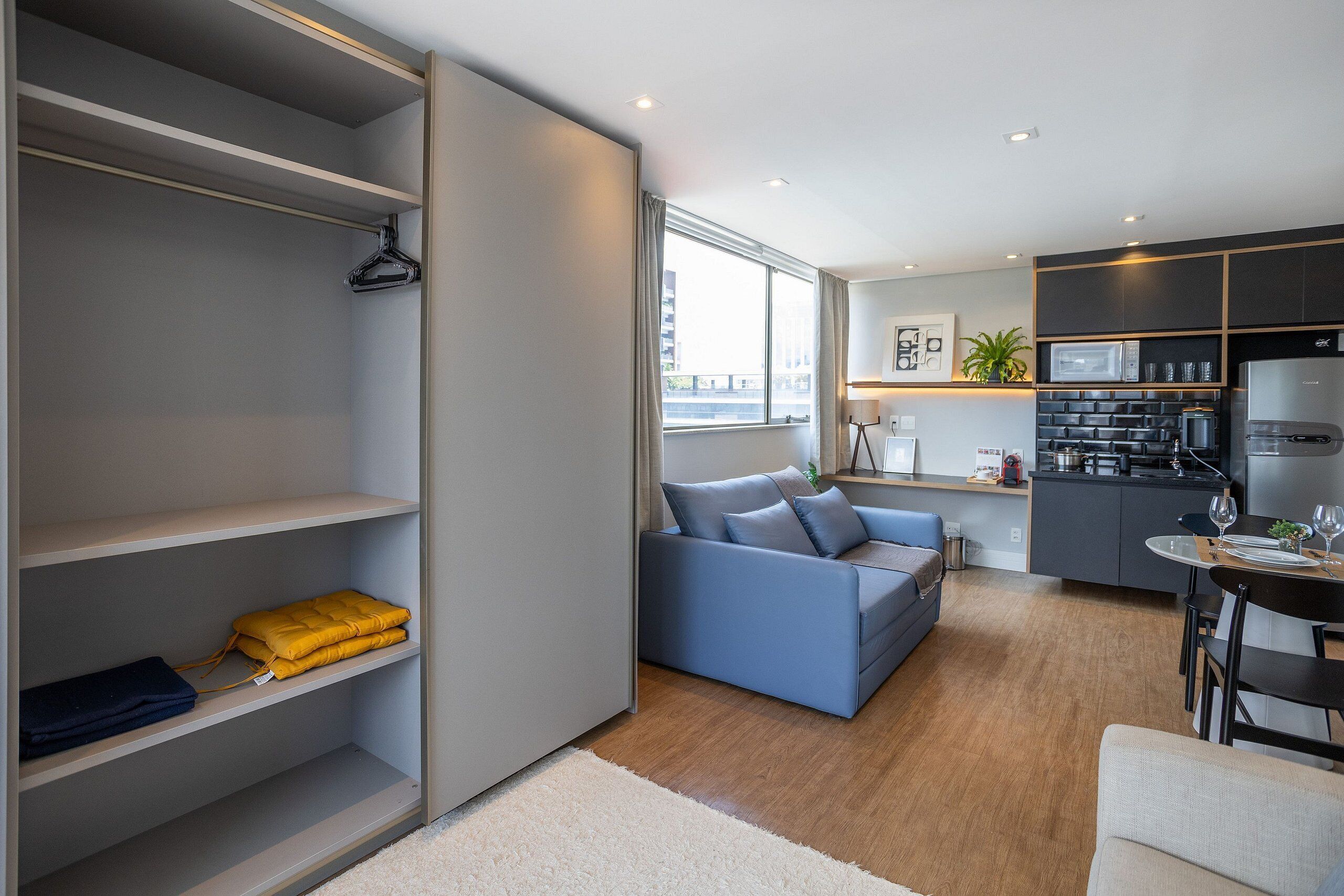 A modern living space with a sofa, a dining area, and a kitchen.