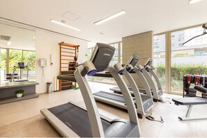 A gym with treadmills, a weight bench, and a wall-mounted exercise machine. - VN Ferreira Lobo (São Paulo)