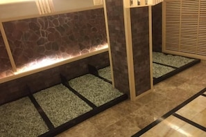 A reception area with a stone wall, a tiled floor, and a wooden partition.