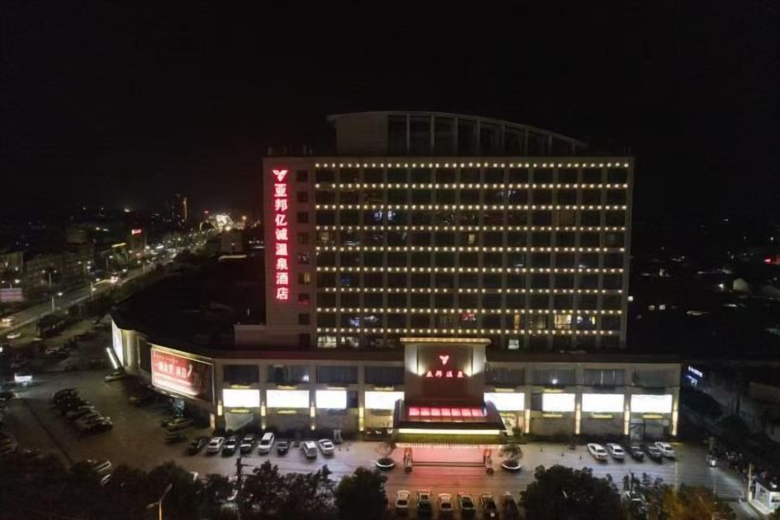 A multi-story hotel with a prominent entrance and a parking area.