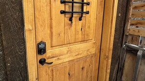 A wooden door with a metal grid lock and a keyhole.