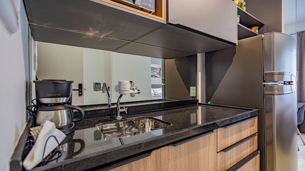 A modern kitchen with a stainless steel refrigerator, a coffee maker, and a sink. - Residencial ID Ibirapuera (São Paulo)