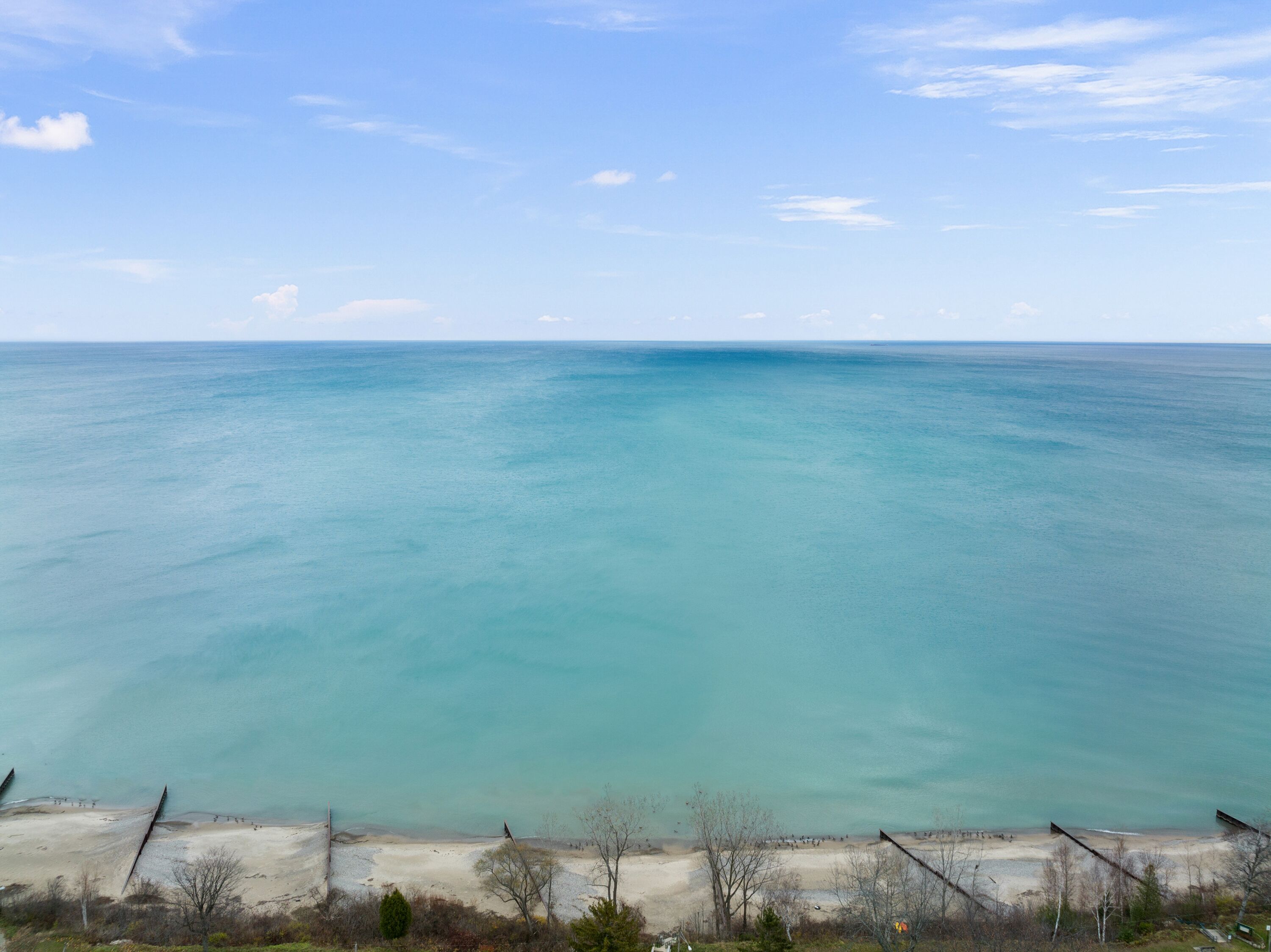 A beach with clear turquoise water and a sandy shore.