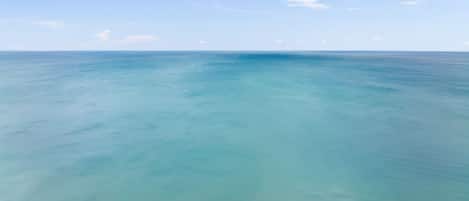 A beach with clear turquoise water and a sandy shore.