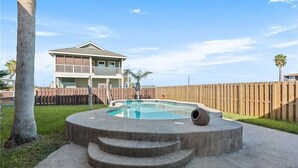 A two-story house with a backyard swimming pool, a hot tub, and a wooden fence. - Perfect getaway for all!  Fish and hunt with all the comforts of home! (Port Mansfield)
