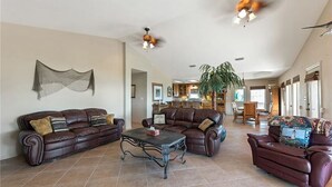 A spacious living room with leather sofas, a coffee table, and ceiling fans. - Perfect getaway for all!  Fish and hunt with all the comforts of home! (Port Mansfield)