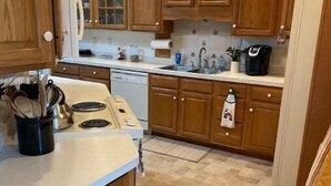 A kitchen with wooden cabinets, a stove, and a dishwasher. - The Berg Life:  Relax, Fish & Explore the Crystal Co (Marshallberg)