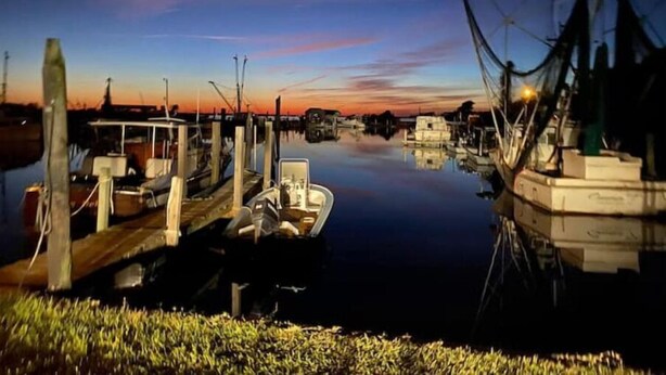 A marina with boats docked at wooden piers, calm water, and a sunset sky. - The Berg Life:  Relax, Fish & Explore the Crystal Co (Marshallberg)