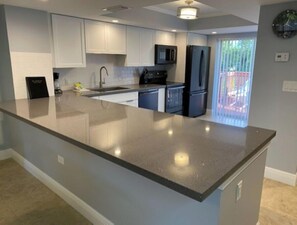 Enjoy cooking in this well-equipped kitchen with a large island countertop and modern cabinetry.