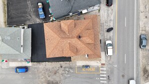 An aerial view of a parking lot with a 'NO PARKING' sign, a blue car, and a white car. - Hampton Beach ♡ Ocean Retreat - Steps From The Sand and Strip! (Hampton)