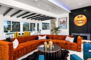 A modern living room with a sectional sofa, a round coffee table, and a fireplace.