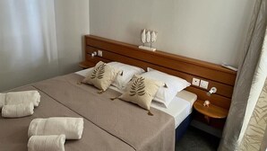 Un lit bien fait, avec une tête de lit en bois, une table de chevet avec une lampe et un rideau sur le côté droit.