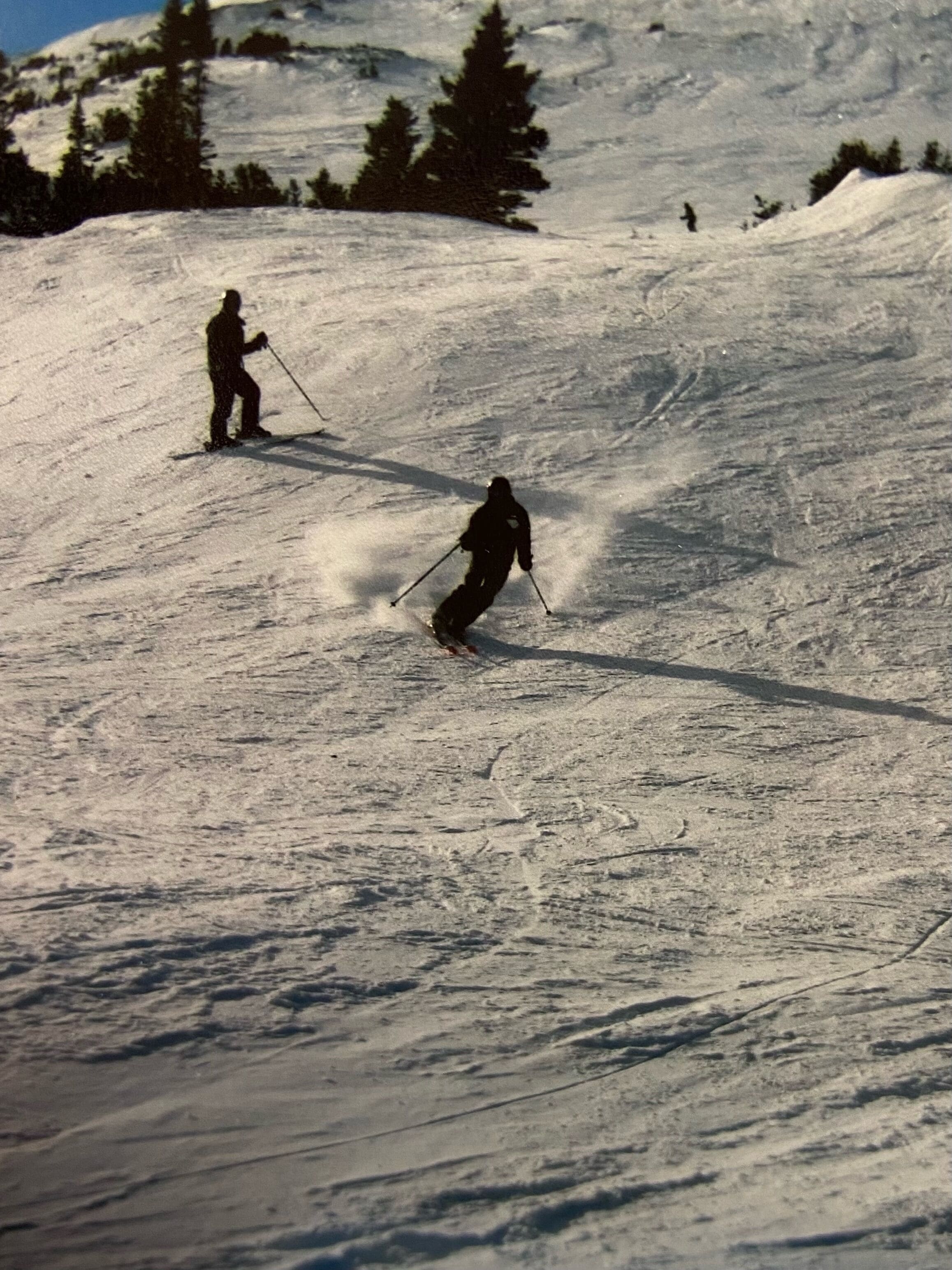 A snowy ski slope with skiers.