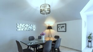 A modern dining area with a glass table, six chairs, a vase with flowers, a floor lamp, a world map, and a decorative wall piece. - Apartment in Kaštel Novi with Balcony, Air condition, WIFI, Washing machine (5105-1) (Kaštel Novi)