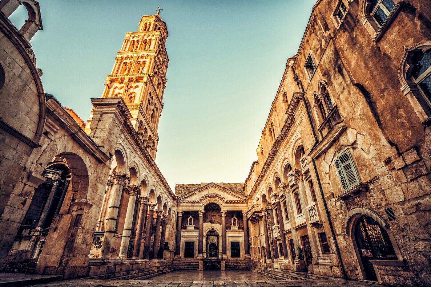A historic building with a prominent tower, arched doorways, and classical architecture.