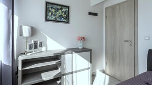 A modern bedroom with a wooden wardrobe, a bedside table with a lamp, and a framed abstract painting on the wall. - Apartment in Kaštel Novi with Balcony, Air condition, WIFI, Washing machine (5105-1) (Kaštel Novi)