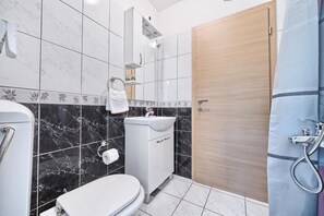 Ein Badezimmer mit Toilette, Waschbecken und Dusche.