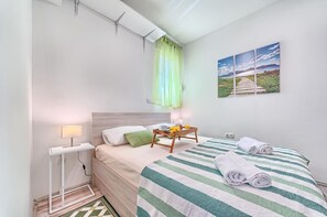 Ein Hotelzimmer mit Bett, Nachttisch, Lampe und einem Bild an der Wand.