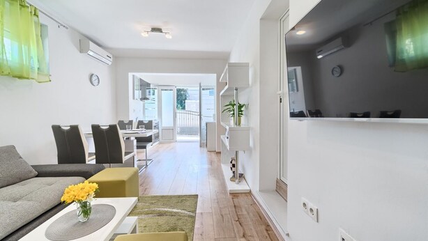 A modern living room with a sofa, coffee table, and a dining area with chairs. There is a staircase leading to an upper floor. - Apartment in Kaštel Lukšić with Terrace, Air condition, WIFI, Washing machine (5107-2) (Kaštel Lukšic)