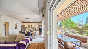 A modern living room with a sofa, dining table, and kitchen in the background. - Apartment in Kaštel Lukšić with Terrace, Air condition, WIFI, Washing machine (5107-3) (Kaštel Lukšic)