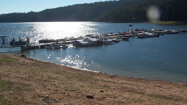 A lakeside dock with boats and a clear view of the lake.
