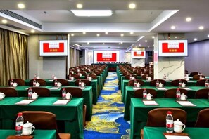 A conference room with rows of tables, chairs, and a carpeted floor. - Ramada by Wyndham Zhangjiajie (Zhangjiajie)