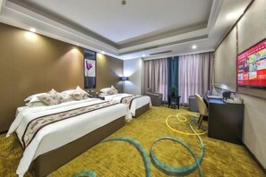 Habitación de hotel con dos camas, un escritorio, una silla, un televisor y un amplio ventanal con cortinas.