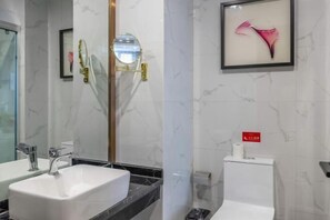 Ein modernes Badezimmer mit zwei Waschbecken, einem Spiegel, einem gerahmten Kunstwerk und einer Toilette.