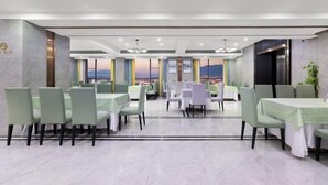 A modern dining area with multiple tables and chairs, large windows with a view, and a clean, contemporary design. - Ramada by Wyndham Zhangjiajie (Zhangjiajie)