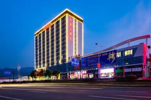 A multi-story hotel with a prominent sign, surrounded by commercial buildings and a busy street. - Ramada by Wyndham Zhangjiajie (Zhangjiajie)
