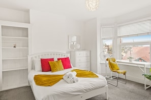 A bedroom with a bed, a desk, a chair, and a window. - Modern 4BR Victorian Home Near Luton Airport (Luton)