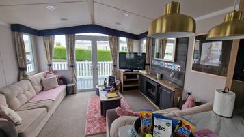 Departamento, varias camas | Área de sala de estar | Televisión de 30 pulgadas con canales por cable