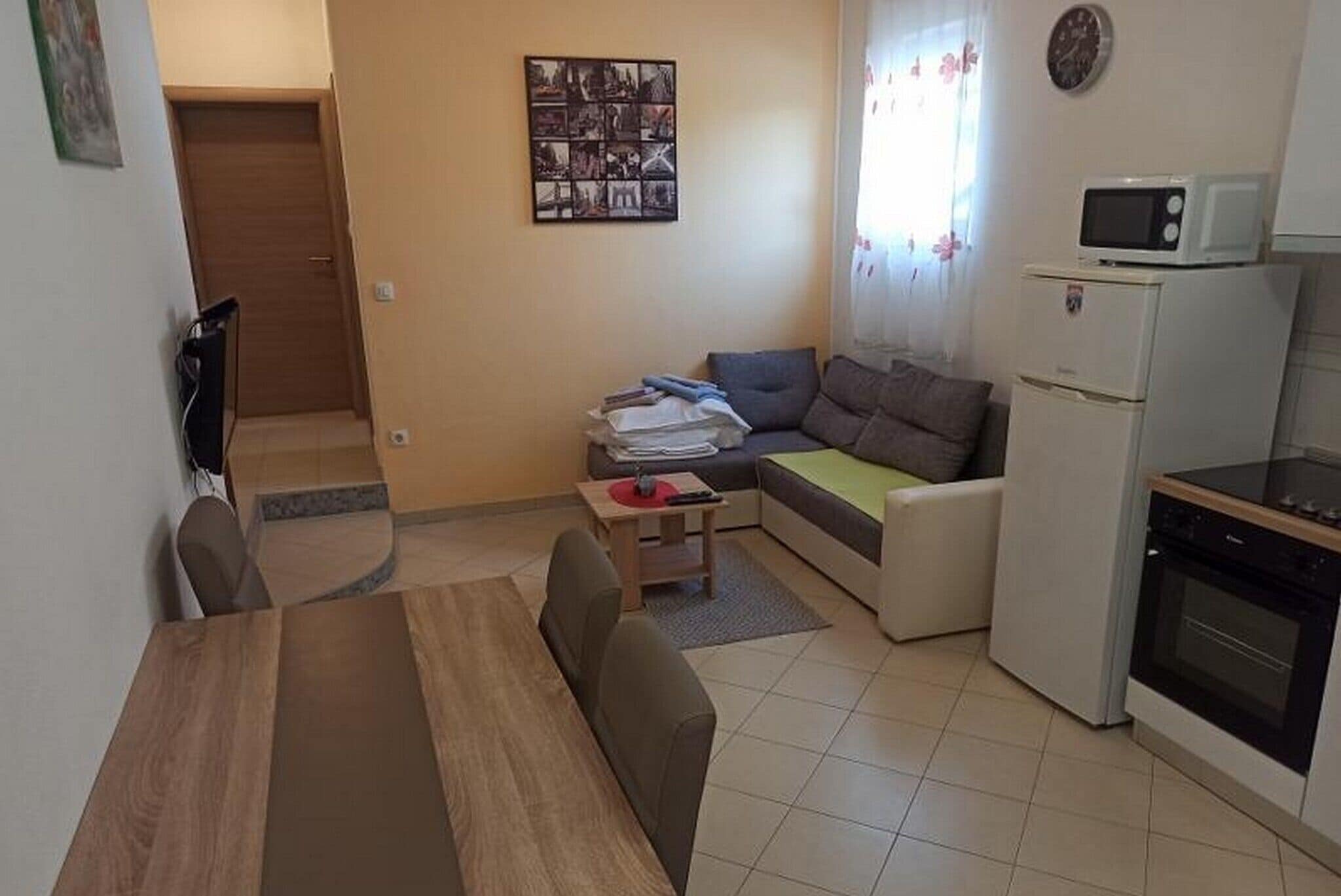 Ein gemütlicher Wohnbereich mit Esstisch, Sofa und Küchenzeile.