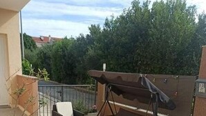 Un patio esterno con un divano, un tavolino e un'altalena.