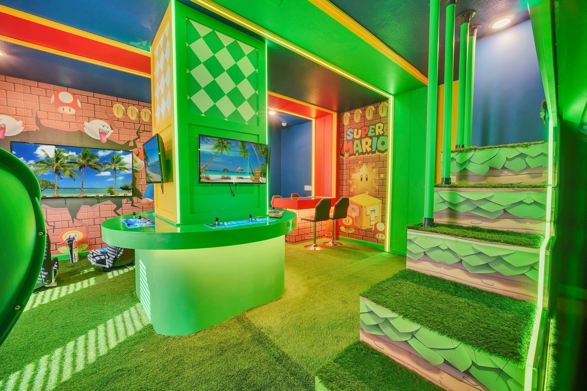 A brightly colored room with a reception desk, a mural of Mario, and a staircase with grass-like steps.