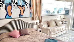A bedroom with a large bed, a bedside table, a lamp, and a view of the outside. - Vesuvio Country House (Campania)