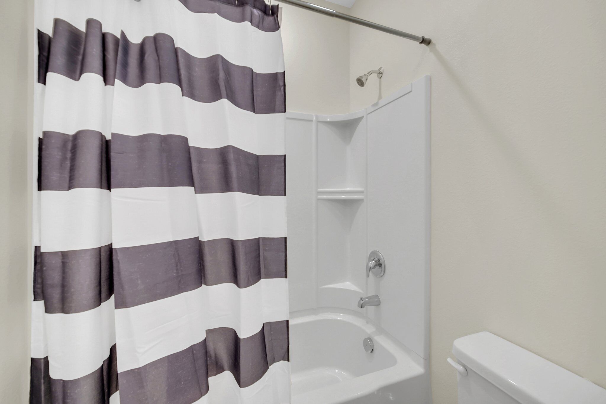 A bathroom with a shower, a bathtub, and a toilet.