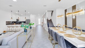A modern kitchen with white cabinets, stainless steel appliances, and pendant lighting. - Spacious Villa With Games Room and Spa-3009PS (Kissimmee)