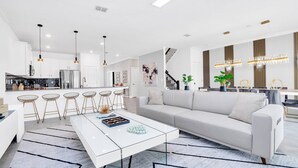 A modern kitchen with white cabinets, stainless steel appliances, and pendant lighting. - Spacious Villa With Games Room and Spa-3009PS (Kissimmee)