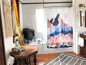 Cozy room with a dining table for two, a side table, and a functional stove.