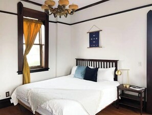 Classic bedroom with a large bed, dark headboard, and elegant chandelier.