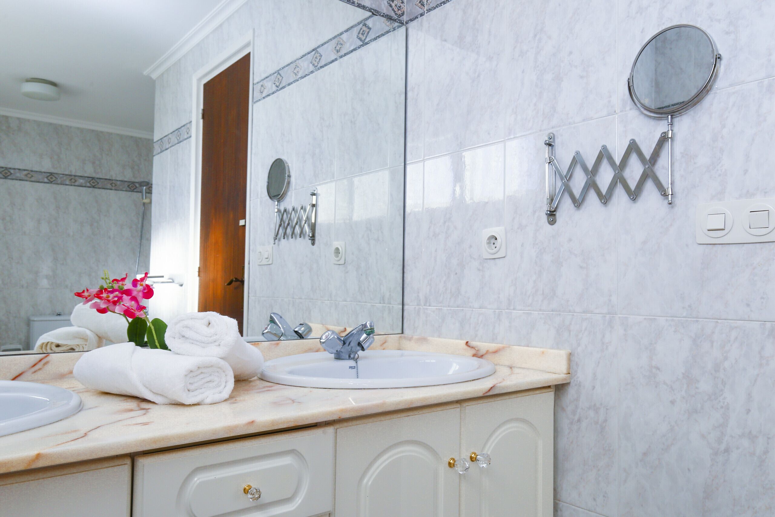 A bathroom with two sinks, a mirror, and a towel rack.