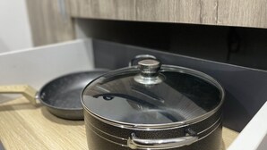 A stainless steel pot with a lid on a wooden countertop. - AMERICAN MALL (Accra)