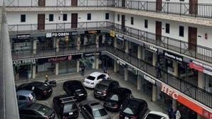 A multi-story building with various shops on the ground floor, including a mobile phone store and a car dealership. - AMERICAN MALL (Accra)
