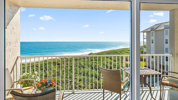 A balcony with a view of the ocean and a building in the background. - Direct Oceanfront Condo on S. Hutchinson Island/Stuart (Stuart)