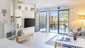 Una sala de estar moderna con un televisor de pantalla plana, un sofá y un comedor.