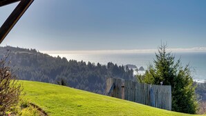 A grassy hillside with a wooden fence and a view of the ocean. - Stunning 360 Ocean Views, Near Redwoods NP! (Smith River)