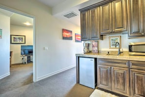 Enjoy cooking in this well-equipped kitchen with a refrigerator, dark cabinetry, and framed artwork.