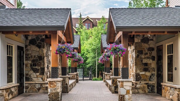 A stone pathway leading to a gated entrance with hanging flower baskets.