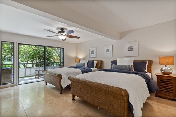 A bedroom with two beds, a ceiling fan, and a view of a balcony. - Panoramic Ocean View Condo on Golf Course close to Beaches (Kihei)